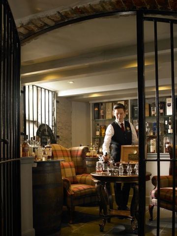 Uriges Weinzimmer mit gemütlichen Sesseln und einem Barkeeper