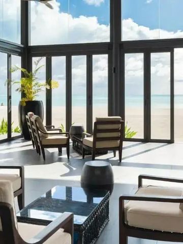 Lounge-Bereich mit Panoramafenstern und Strandblick