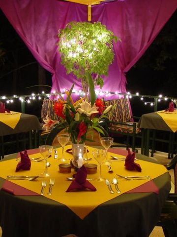 Beleuchtete Restaurantterrasse mit elegantem Gedeck und floraler Dekoration