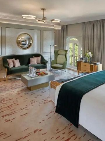 Helles, geräumiges Zimmer mit eleganter Sitzecke und großem Doppelbett.