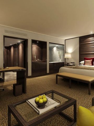 Geräumige Suite mit Schreibtisch, Bett und stimmungsvoller Beleuchtung