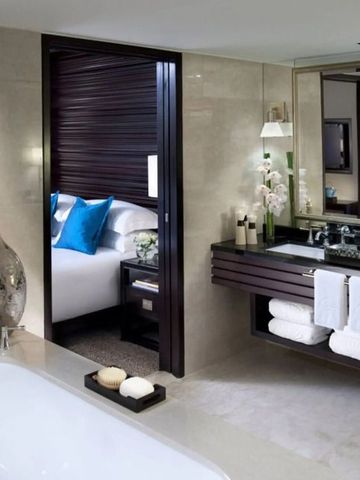 Geräumiges Badezimmer mit eleganter Ausstattung und Blick ins Schlafzimmer