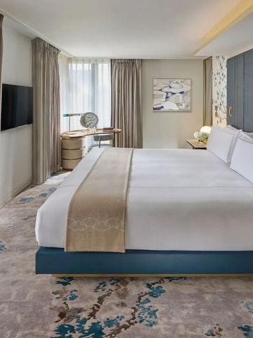 Luxuriöses Schlafzimmer mit Kingsize-Bett und dezenten Dekors in Blau und Beige