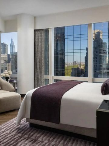 Luxuriöses Schlafzimmer mit Blick auf die Skyline von New York und eleganter Sitzecke.