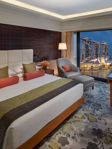 Luxuriöses Zimmer mit großem Fenster und Aussicht auf Marina Bay Sands.