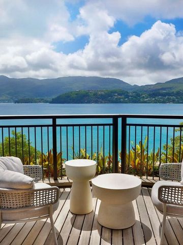 Terrasse mit atemberaubendem Blick auf türkisblaues Meer und grüne Berge.