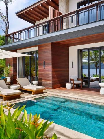 Luxusvilla mit privatem Pool und Liegen auf einer Terrasse im Freien.