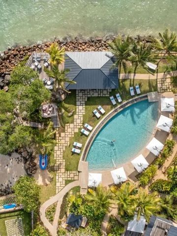 Luftbild des Resorts mit Infinity-Pool, umgeben von tropischer Vegetation am Meer.