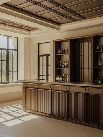 Elegante Bar mit Holzelementen und großen Fenstern