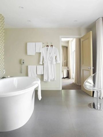 Großes Badezimmer mit stilvoller freistehender Badewanne