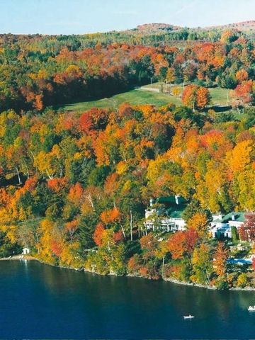 Luftaufnahme von buntem Herbstwald und See beim Manoir Hovey
