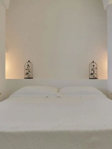 Einladendes Bett mit weißer Bettwäsche und künstlerischer Wanddekoration
