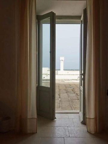 Blick durch offene Türen auf Terrasse mit Meerblick