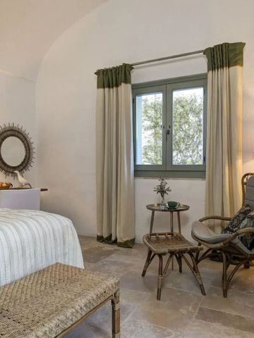 Gemütliches Schlafzimmer mit Sitzbereich und großen Fenstern in einem luxuriösen Hotelzimmer