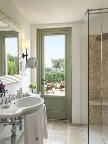 Elegantes Badezimmer mit Glasdusche und Blick auf die Terrasse