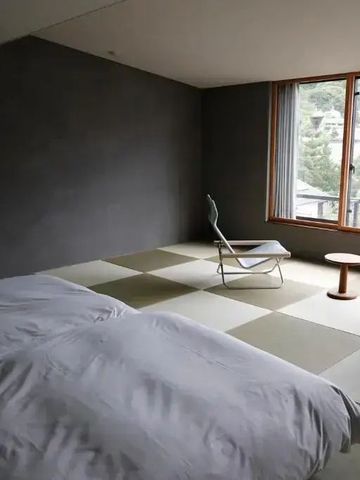 Minimalistisch eingerichtetes Zimmer mit Blick aus dem Fenster auf die Natur
