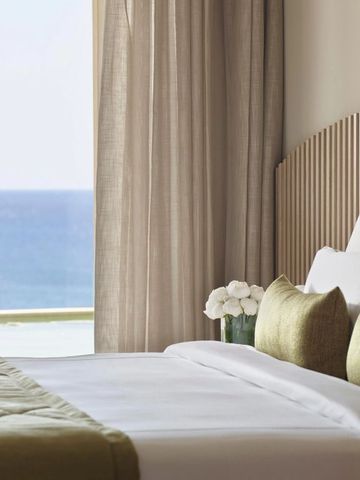 Schönes Schlafzimmer im Hotel mit Blick auf das Meer durch ein großes Fenster