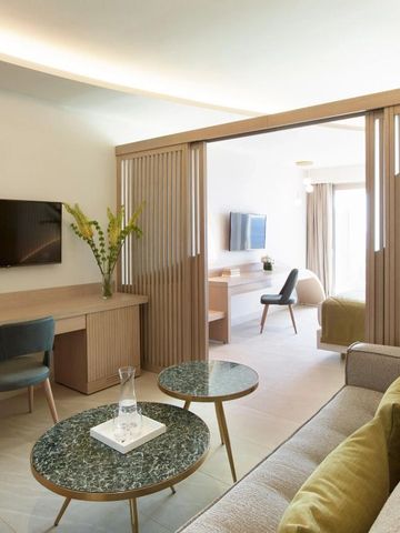 Heller Wohnbereich einer Suite mit modernen Möbeln und Schiebetür zum Schlafzimmer
