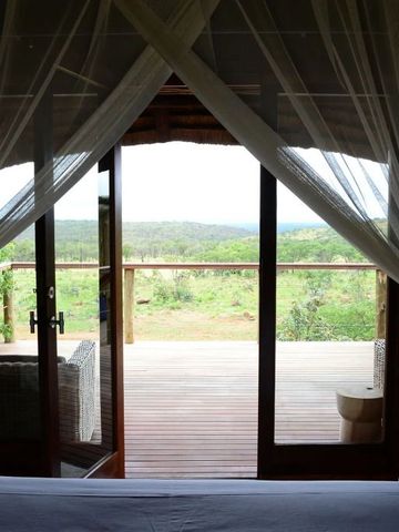 Blick vom Schlafzimmer auf eine Terrasse und Natur
