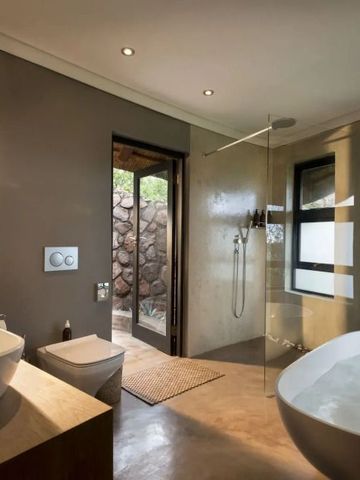 Luxuriöses Badezimmer mit freistehender Badewanne und Glasdusche