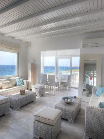Helle Lounge mit Rattanmöbeln und Panoramablick auf das Meer