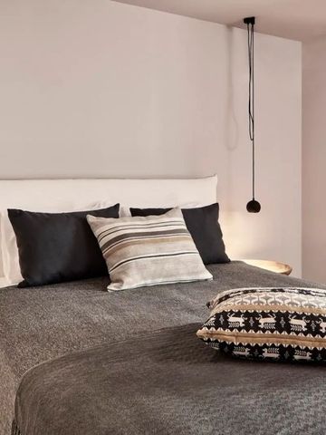 Modernes Schlafzimmer mit Doppelbett und stilvollen Kissen im Minos Beach Art Hotel
