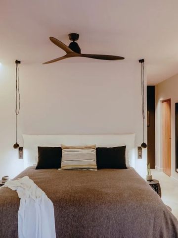 Chic gestaltetes Zimmer mit Deckenventilator und komfortablem Bett im Minos Beach Art Hotel