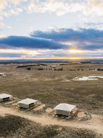 Bogen aus Safarizelten der Safari Lodge um eine Wasserstelle im Wild-Africa-Bereich von oben