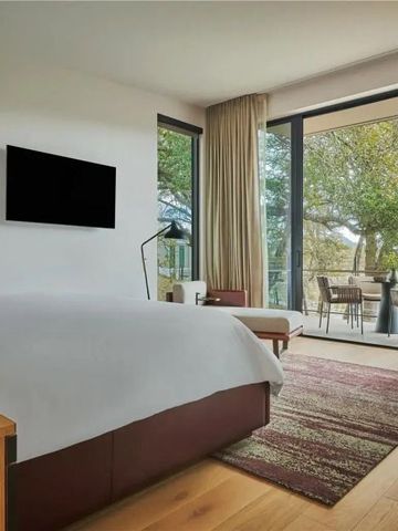 Modernes Zimmer mit Zugang zu einem Balkon im Grünen und natürlichem Licht.