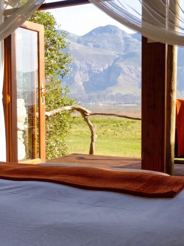 Schlafzimmer mit Blick auf die Berge durch große Glastüren