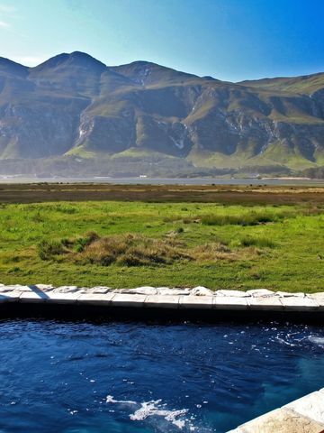 Blick auf einen kleinen Pool mit Berglandschaft im Hintergrund