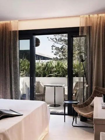 Helles Hotelzimmer mit Terrasse und gemütlicher Sitzecke, moderne Dekoration.