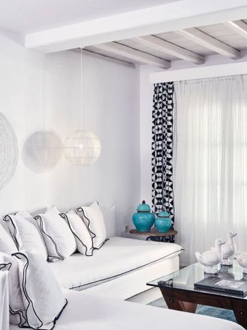 Helles Wohnzimmer mit weißen Möbeln und künstlerischem Dekor