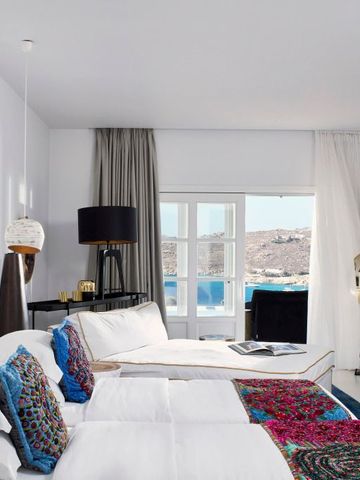 Geräumiges Schlafzimmer mit Meerblick und stilvollen Kissen