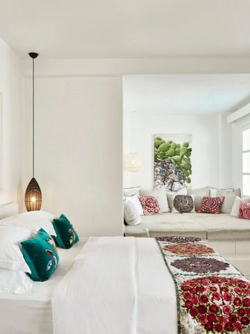 Helles Schlafzimmer mit gemütlichem Sofa und bunten Kissen