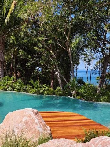 Infinity-Pool umgeben von tropischen Bäumen und Blick auf das Meer