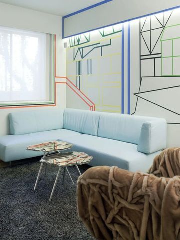 Helle Suite mit moderner Wanddekoration und komfortablen Sitzmöbeln