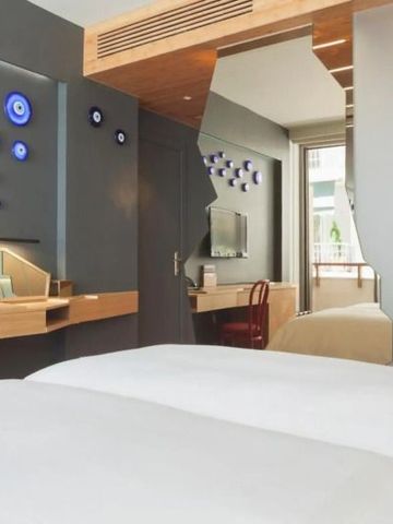 Modernes Hotelzimmer mit Schreibtisch und dekorativen Elementen an der Wand.