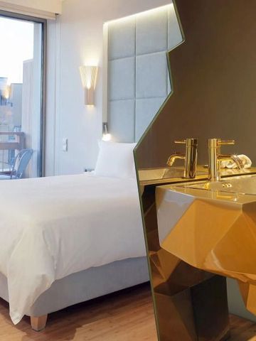 Luxus-Hotelzimmer mit integriertem Waschbereich und goldenen Armaturen.
