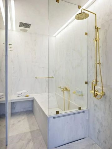 Luxuriöses Badezimmer mit goldenen Armaturen und Marmordesign