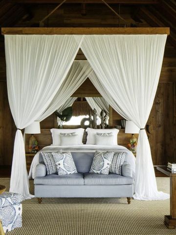 Hölzernes Schlafzimmer mit Himmelbett und eleganter Dekoration im Nihi Sumba