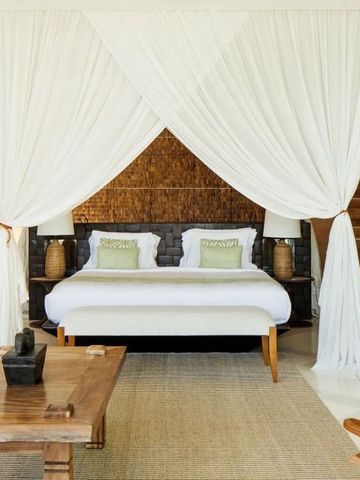 Geräumiges Schlafzimmer mit weißem Baldachin im Luxusresort Nihi Sumba