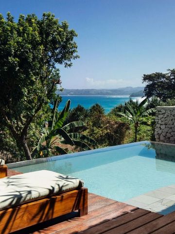 Infinity-Pool mit Blick auf das Meer und die tropische Landschaft
