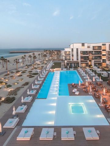Infinity-Pool des Resorts mit Strandzugang und luxuriösen Liegen