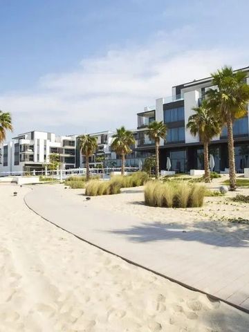 Hoteleingang mit moderner Architektur und Palmen an einem sonnigen Strand
