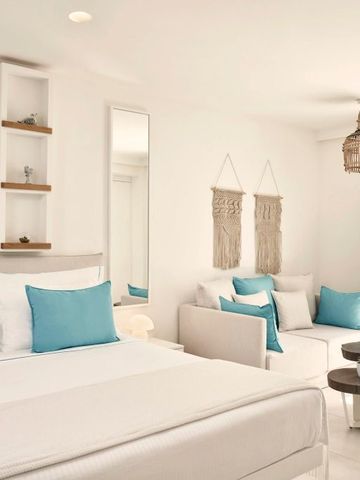 Modernes Hotelzimmer mit Sofaecke und kunstvollen Wanddekorationen.