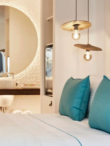 Detailansicht eines Bettes mit eleganten Lampen und stilvollem Spiegeldesign.