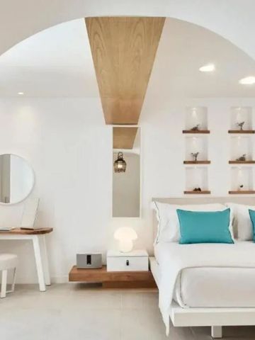 Minimalistisch gestaltetes Zimmer mit weißem Interieur und Holzakzenten.