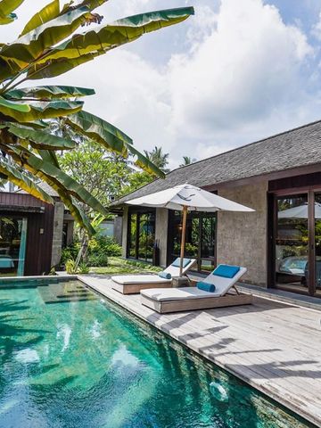 Private Villa mit Pool und Sonnenliegen umgeben von tropischer Vegetation