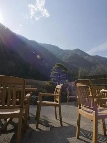 Terrasse mit Sitzmöbeln und sonnigem Bergpanorama.